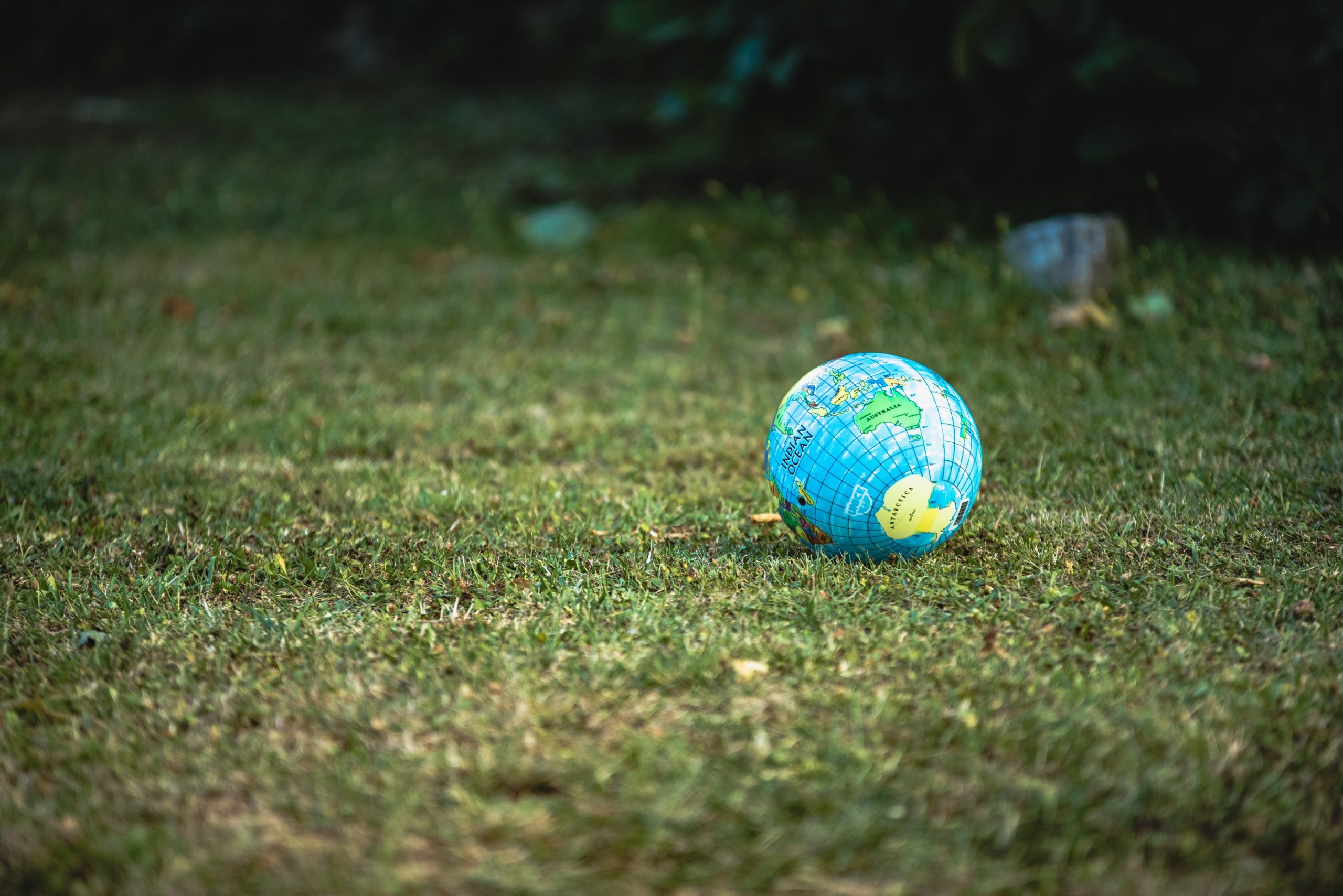 Das Foto zeigt eine kleine Weltkugel, die auf einer grünen Rasenfläche liegt. Sie symbolisiert einen grünen Alltag für mehr Umweltschutz im täglichen Leben.